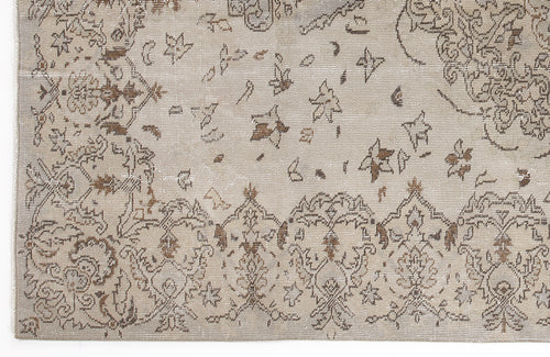 Load image 1 in gallery view. Beige and brown distressed rug with a traditional floral medallion pattern and scattered botanical motifs.