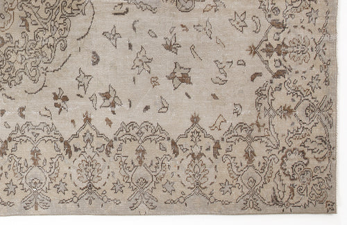 Load image 1 in gallery view. Beige and brown distressed rug with a traditional floral medallion border and scattered star-like motifs.