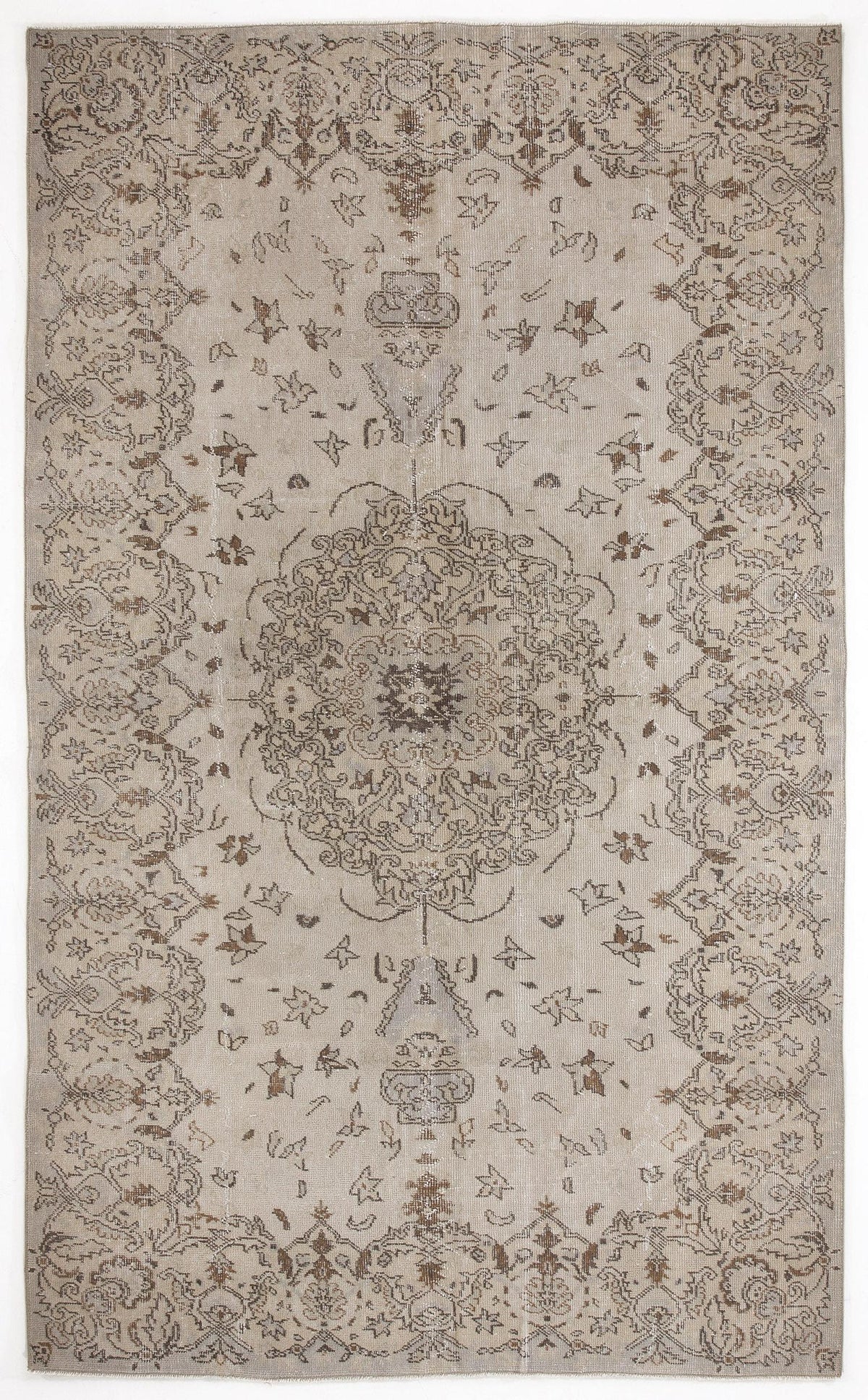 Beige and brown distressed area rug with a central floral medallion and ornate border pattern.