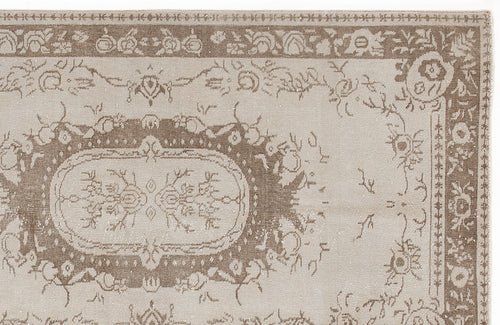 Load image 1 in gallery view. Taupe and beige traditional rug with a distressed floral medallion pattern and a decorative border.