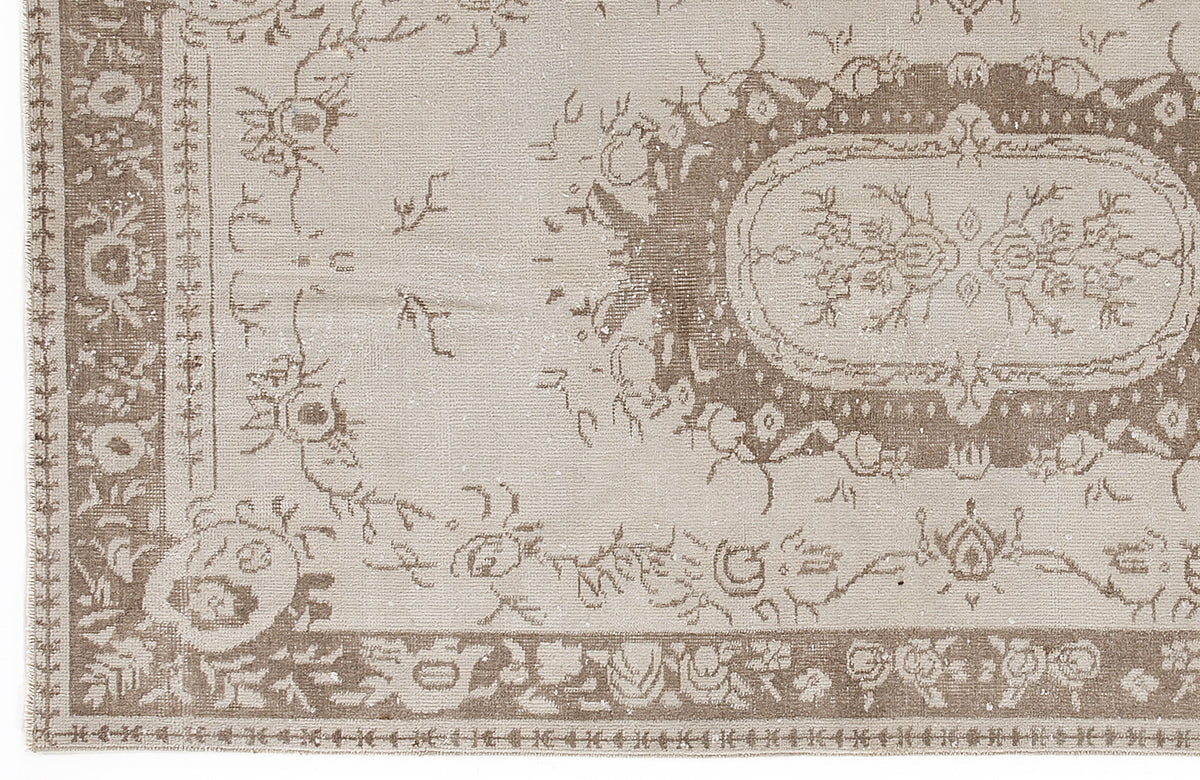 Beige and taupe vintage-style rug with a distressed floral medallion pattern and ornate border.