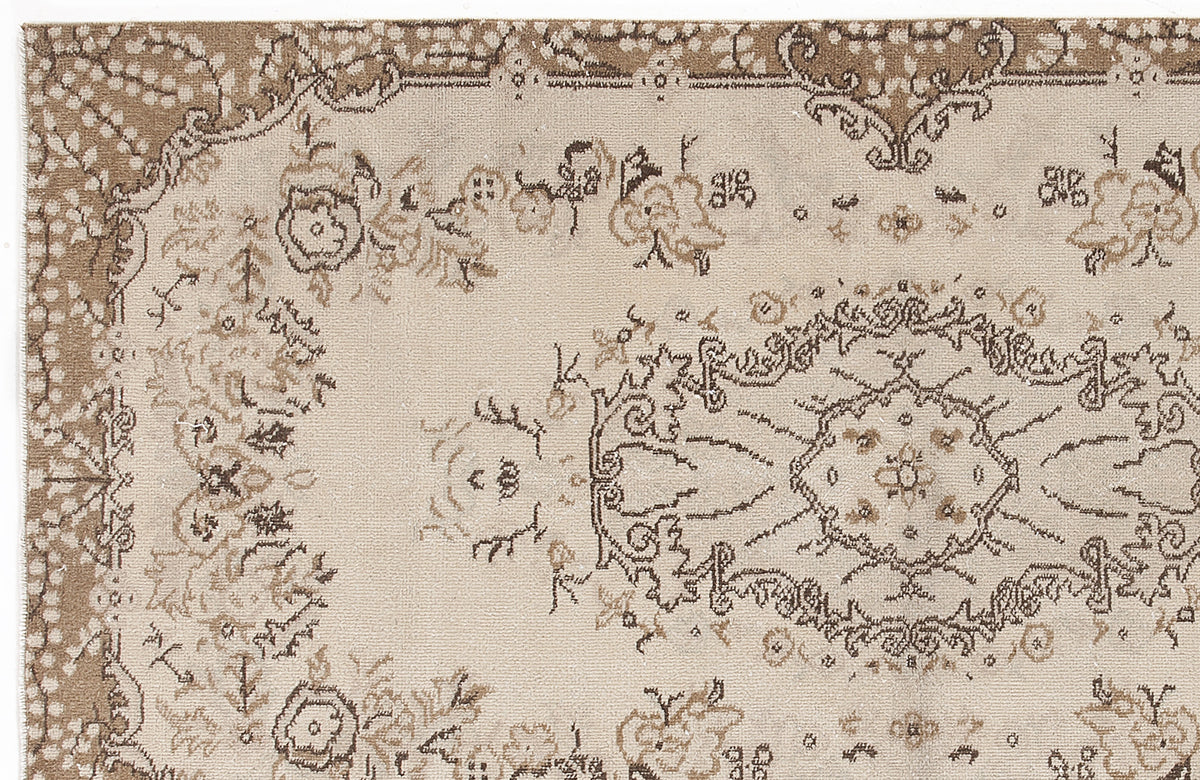 Beige and brown rug with a distressed traditional floral medallion pattern and ornate border.