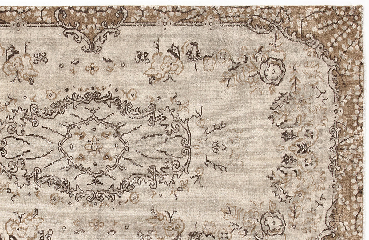 Beige and brown traditional rug with a central floral medallion and ornate border pattern.