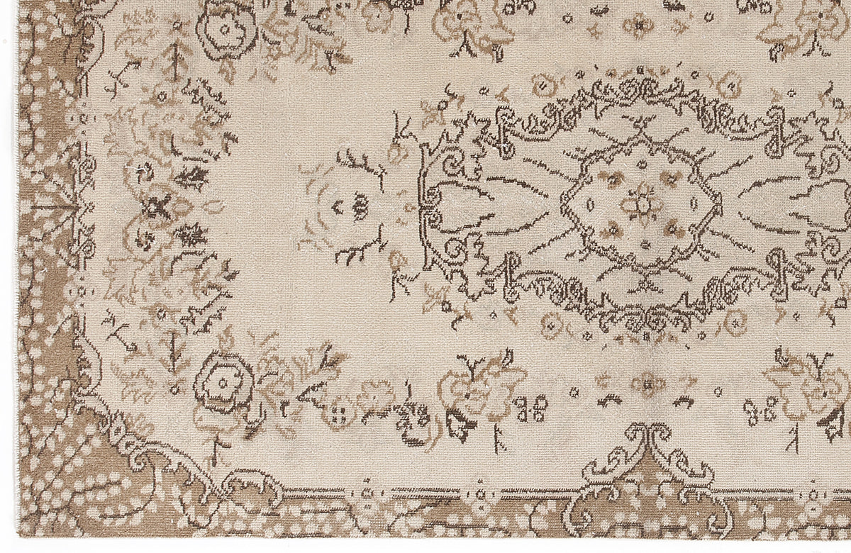 Beige and taupe traditional rug with a distressed floral medallion pattern and ornate border.
