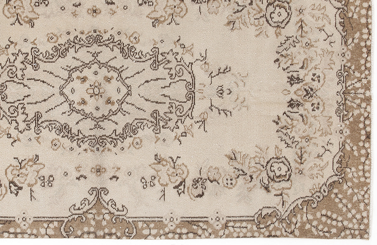 Beige and brown traditional rug with a distressed floral medallion pattern and ornate border.