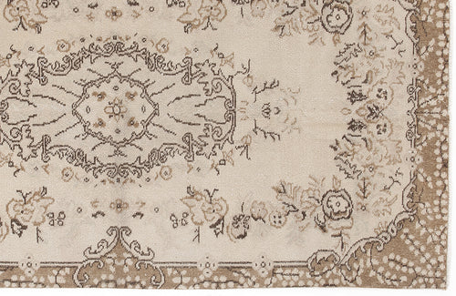 Load image 1 in gallery view. Beige and brown traditional rug with a distressed floral medallion pattern and ornate border.