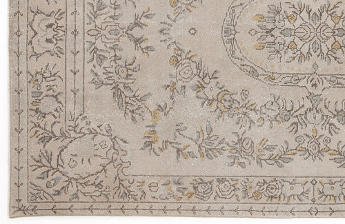 Load image 1 in gallery view. Beige rug with a distressed floral medallion pattern in grey and muted yellow, featuring a decorative border.