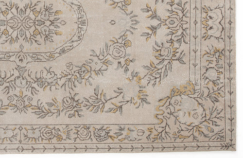Load image 1 in gallery view. Beige rug with a grey and mustard yellow floral medallion pattern and a decorative border.