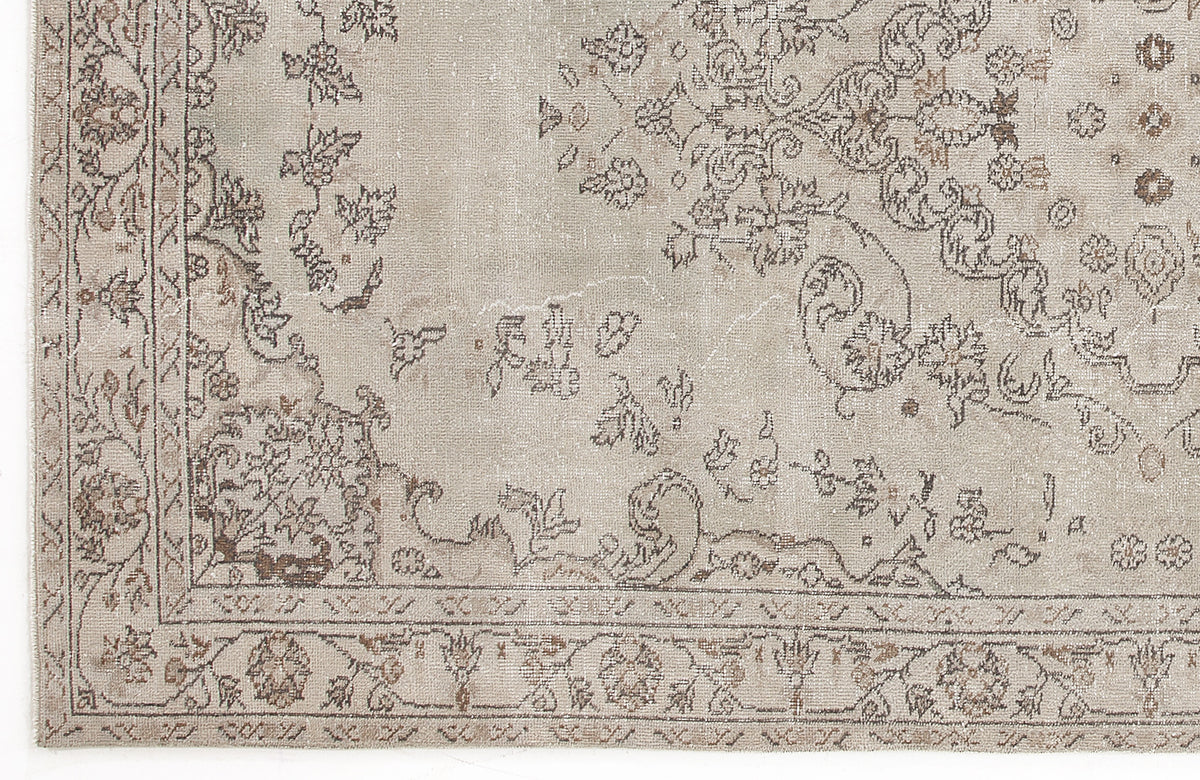 Beige and taupe distressed rug with a traditional floral medallion pattern and ornate border.