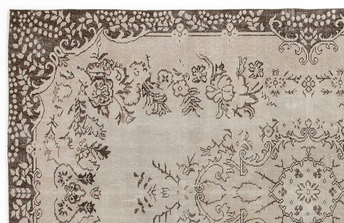 Taupe and dark brown rug with a traditional floral medallion pattern and decorative border.