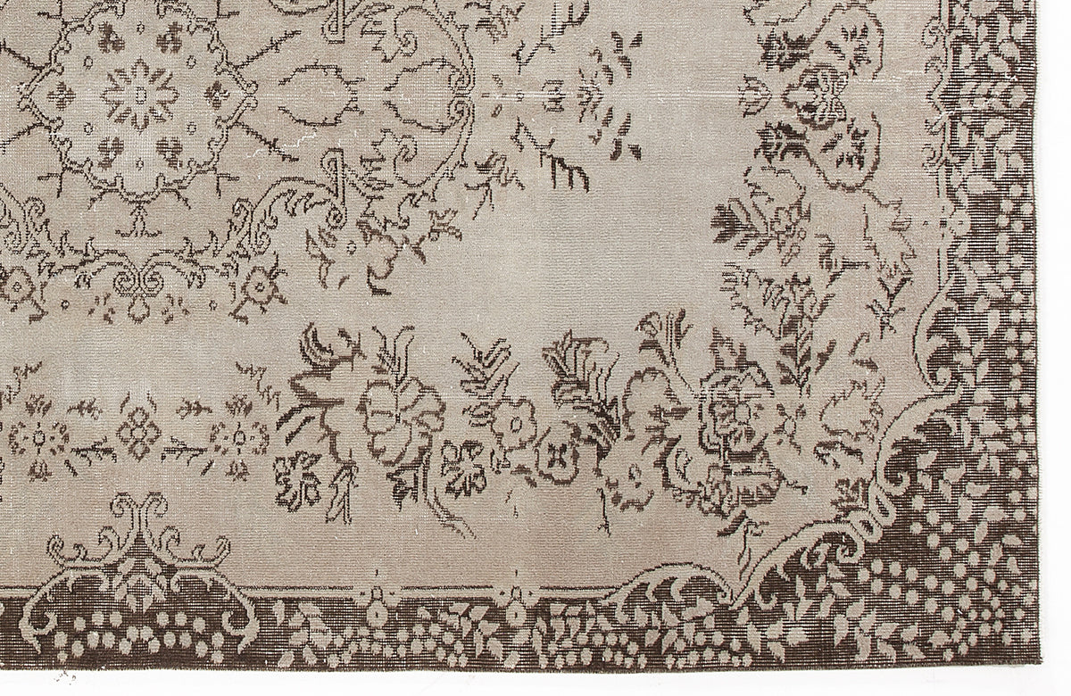 Taupe and dark brown rug with a traditional floral medallion pattern and a decorative border.