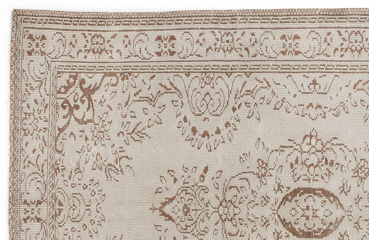 Beige and brown rug with a traditional floral medallion pattern and a detailed border.