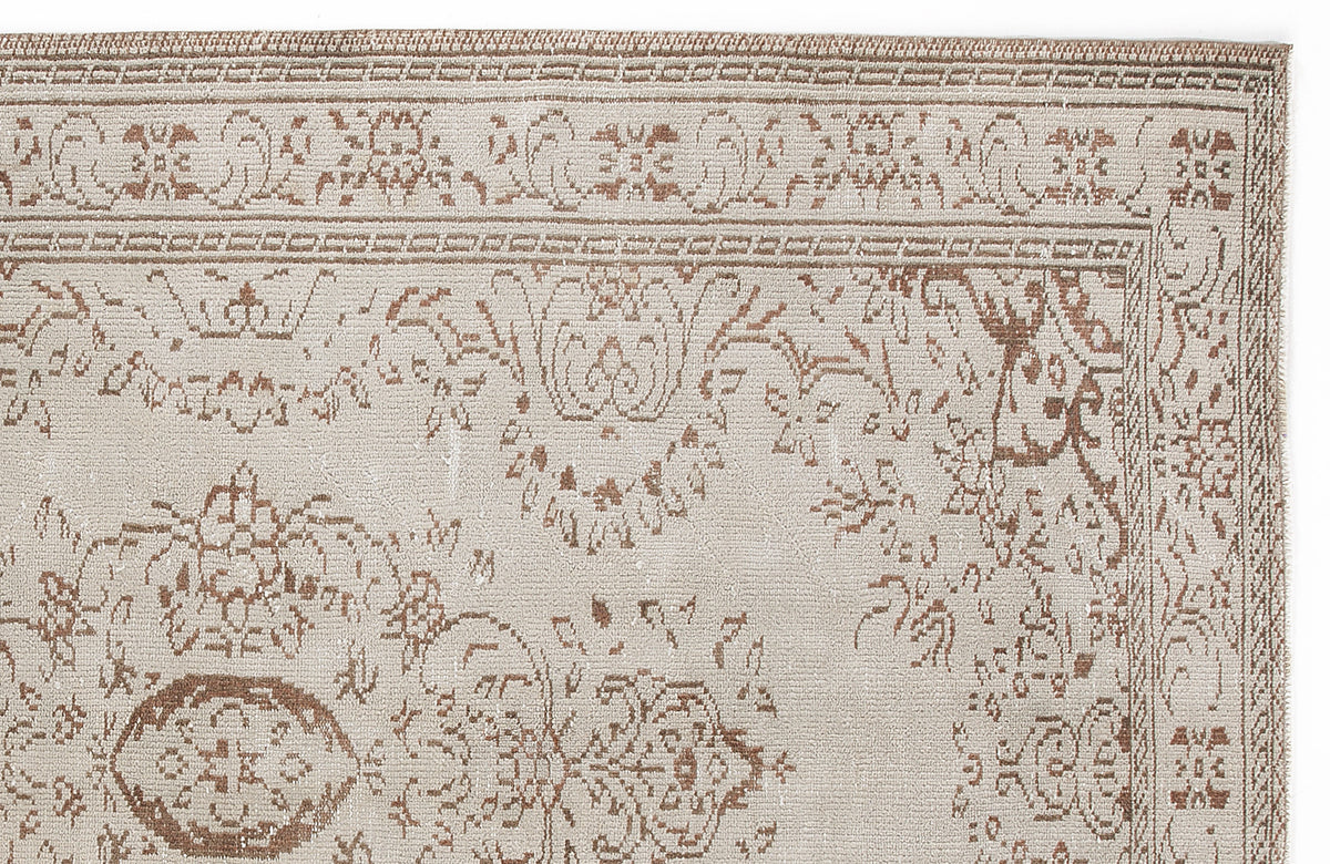Beige and brown rug with a traditional floral medallion pattern and a decorative border on a white background.