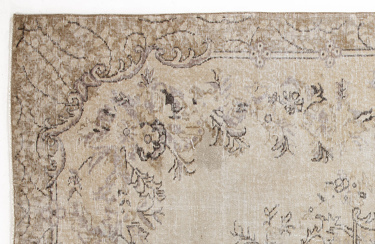 Beige and taupe vintage-style rug with a distressed floral medallion pattern on a white background.