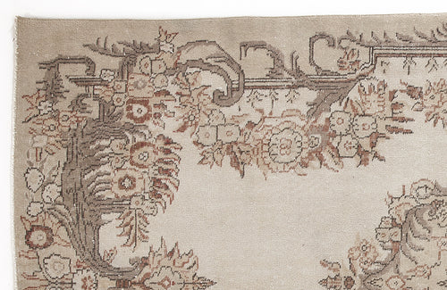 Load image 1 in gallery view. Beige rug with a distressed floral and vine border pattern in shades of brown and terracotta.