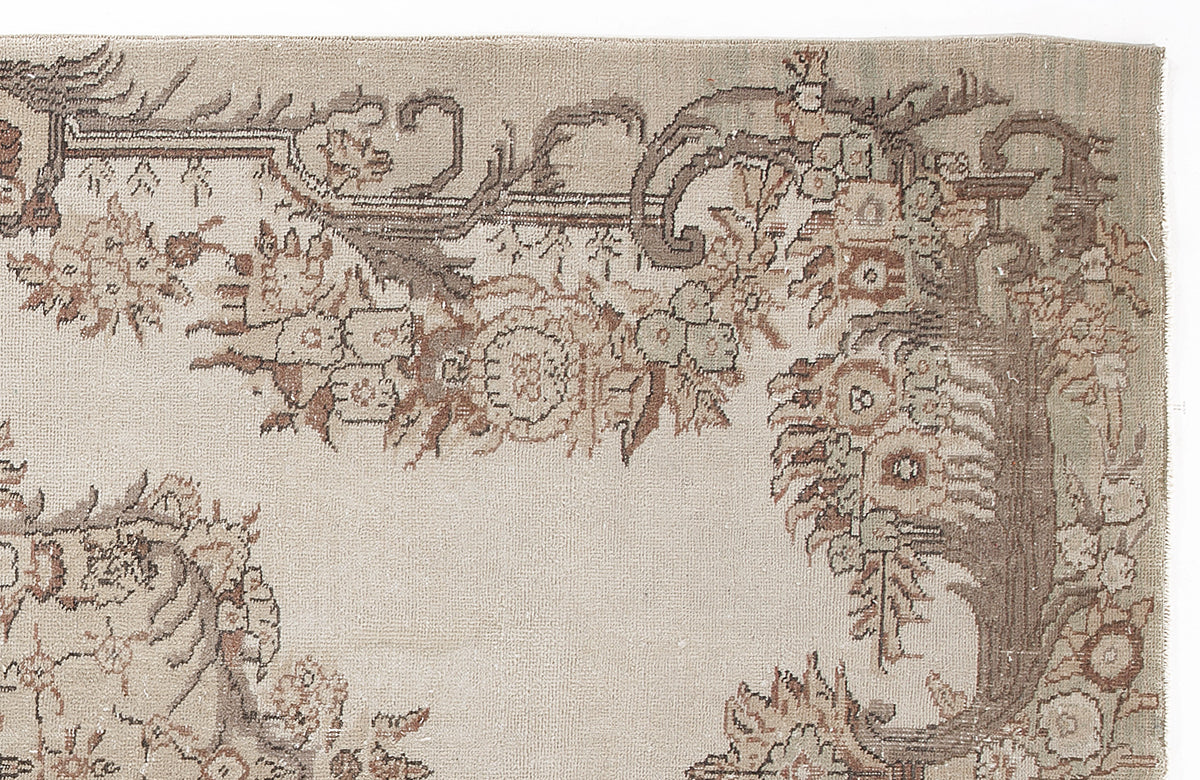 Beige and brown rug with a traditional floral border pattern on a white background.