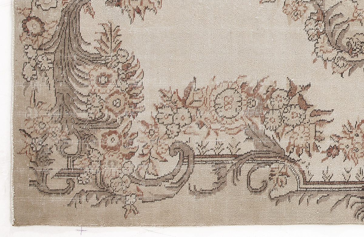 Beige and taupe vintage-style rug with a distressed floral medallion pattern.