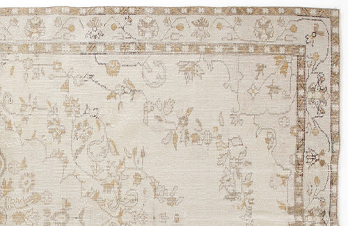 Load image 1 in gallery view. Beige and tan rug with a faded floral pattern and a geometric border on a white background.
