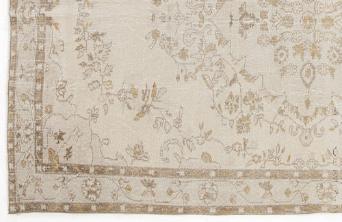Load image 1 in gallery view. Beige and tan distressed rug with a faded floral medallion pattern and a geometric border.
