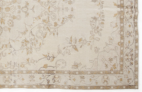 Load image 1 in gallery view. Beige and tan rug with a faded, distressed floral pattern and a decorative geometric border.
