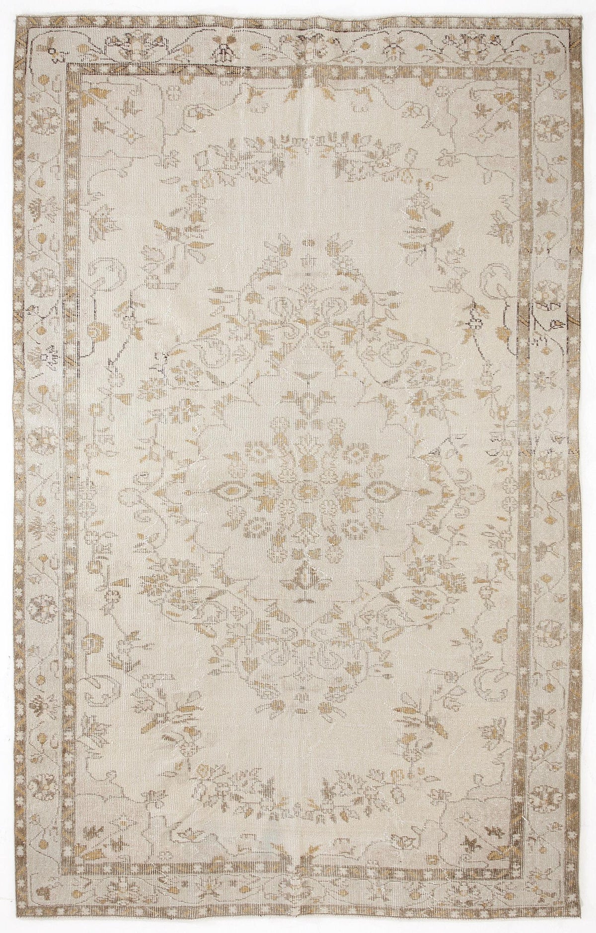 Beige and tan distressed vintage-style rug with a central floral medallion and a decorative border.