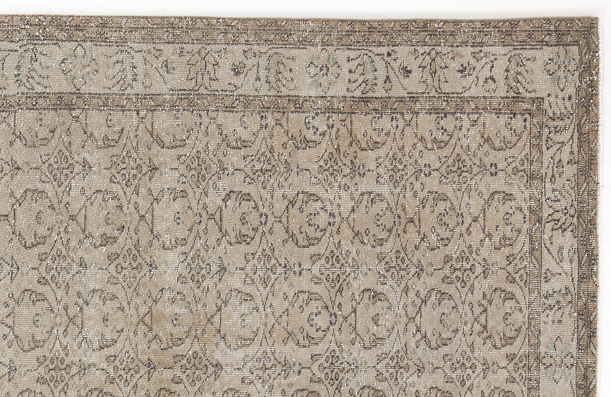 Beige and taupe vintage-style rug with a distressed floral medallion pattern and a decorative border.