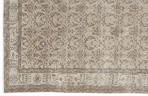 Load image 1 in gallery view. Beige and taupe distressed rug with a repeating floral medallion pattern and a decorative border.