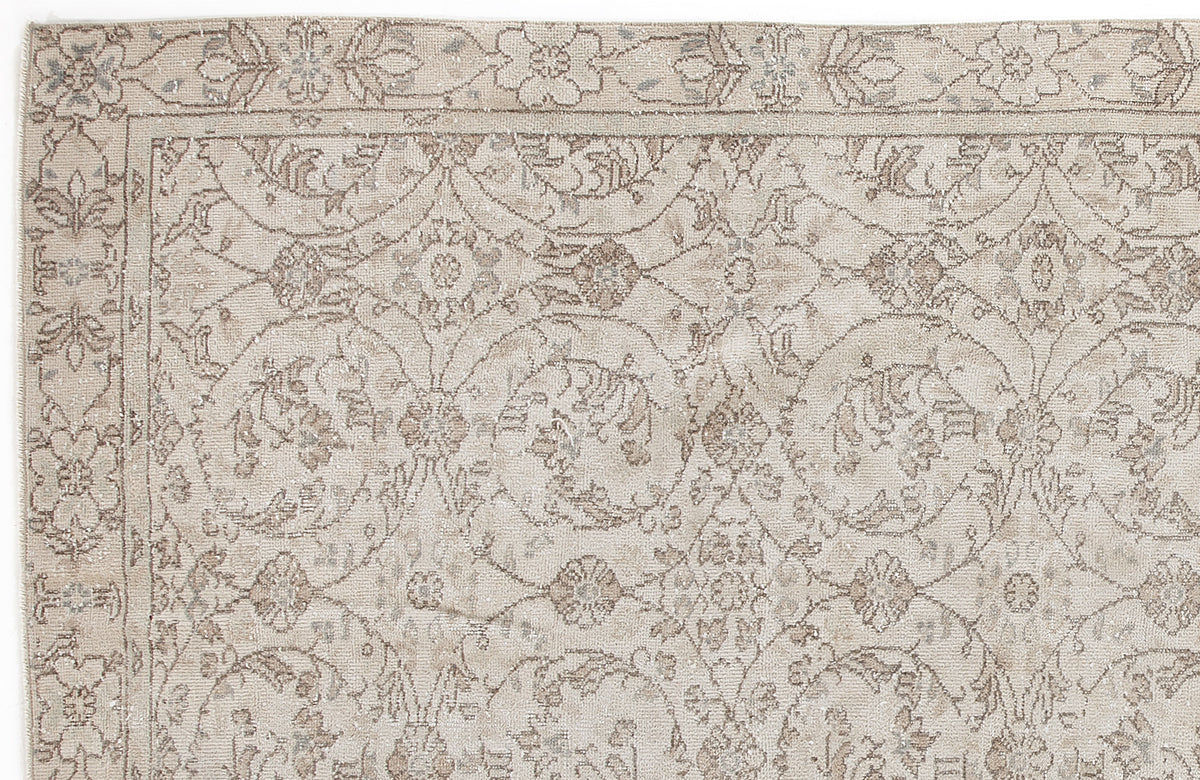 Beige and taupe traditional rug with a distressed floral medallion pattern and a decorative border.