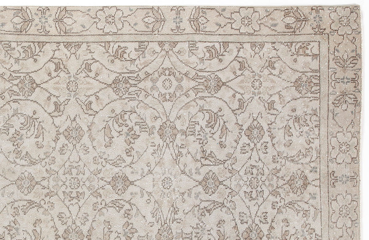 Beige and taupe traditional rug with a distressed floral vine pattern and a decorative border.
