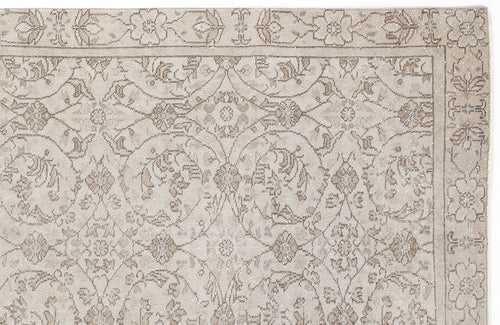 Load image 1 in gallery view. Beige and taupe traditional rug with a distressed floral vine pattern and a decorative border.