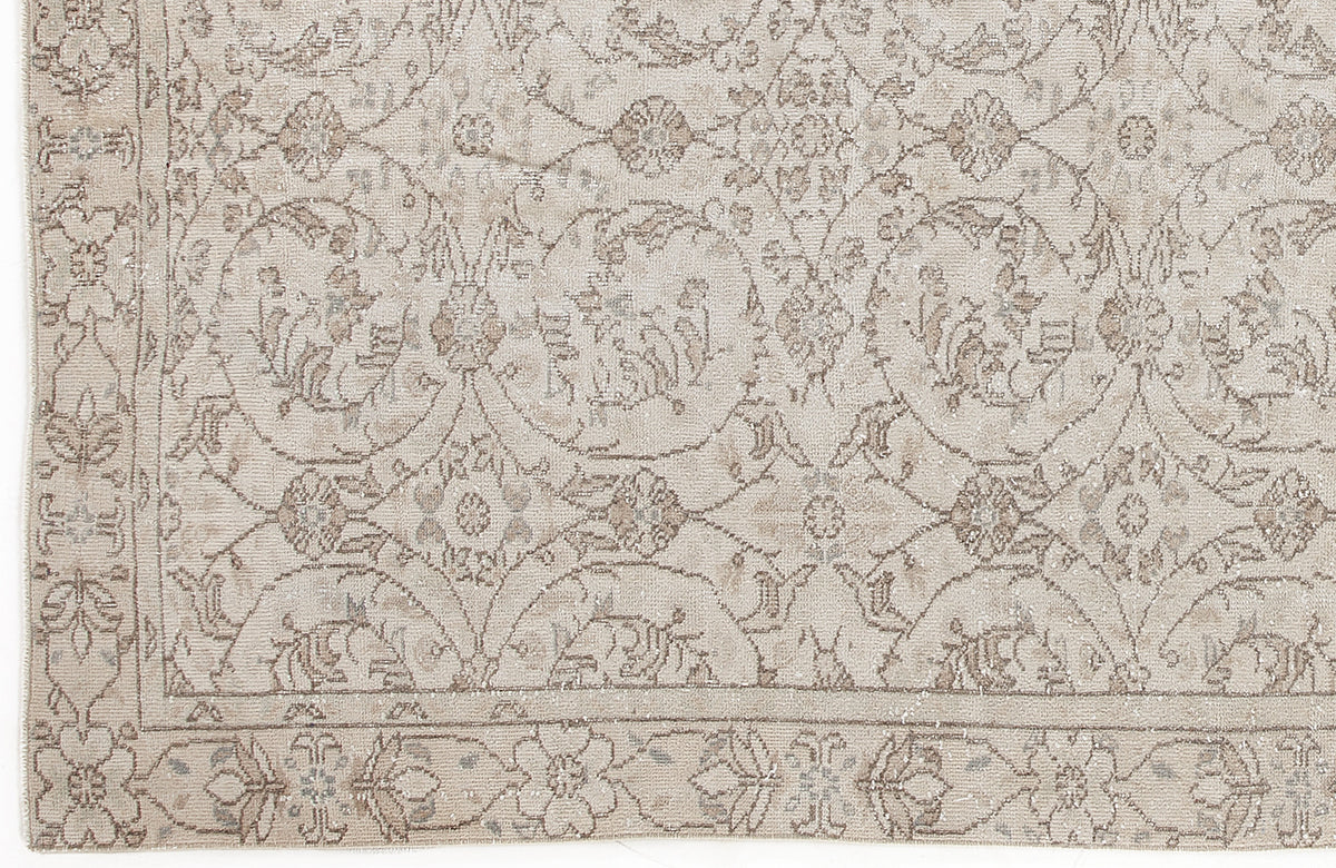 Beige and taupe rug with a traditional floral medallion pattern and a decorative border.