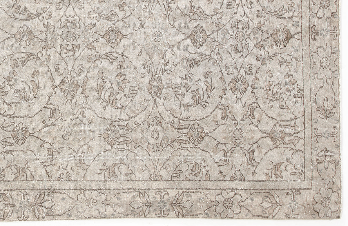 Beige and taupe traditional rug with a distressed floral medallion pattern and a decorative border.