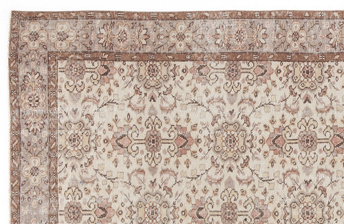 Load image 1 in gallery view. Distressed beige and brown traditional rug with a faded floral medallion pattern and a wide decorative border.