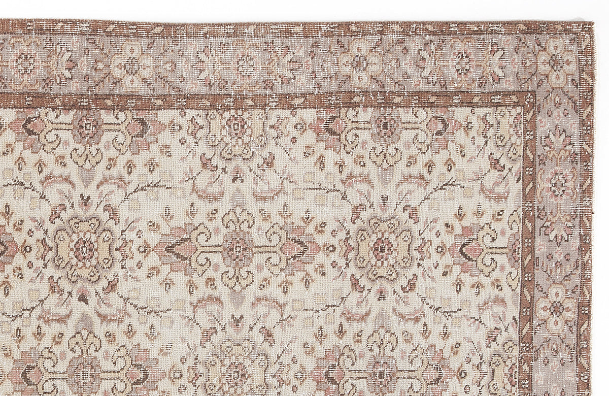 Beige and brown traditional rug with a distressed floral medallion pattern and a decorative border.