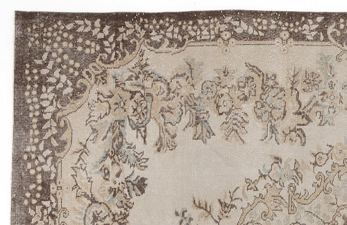 Load image 1 in gallery view. Brown and beige vintage-style rug with a distressed floral border and central botanical motif.