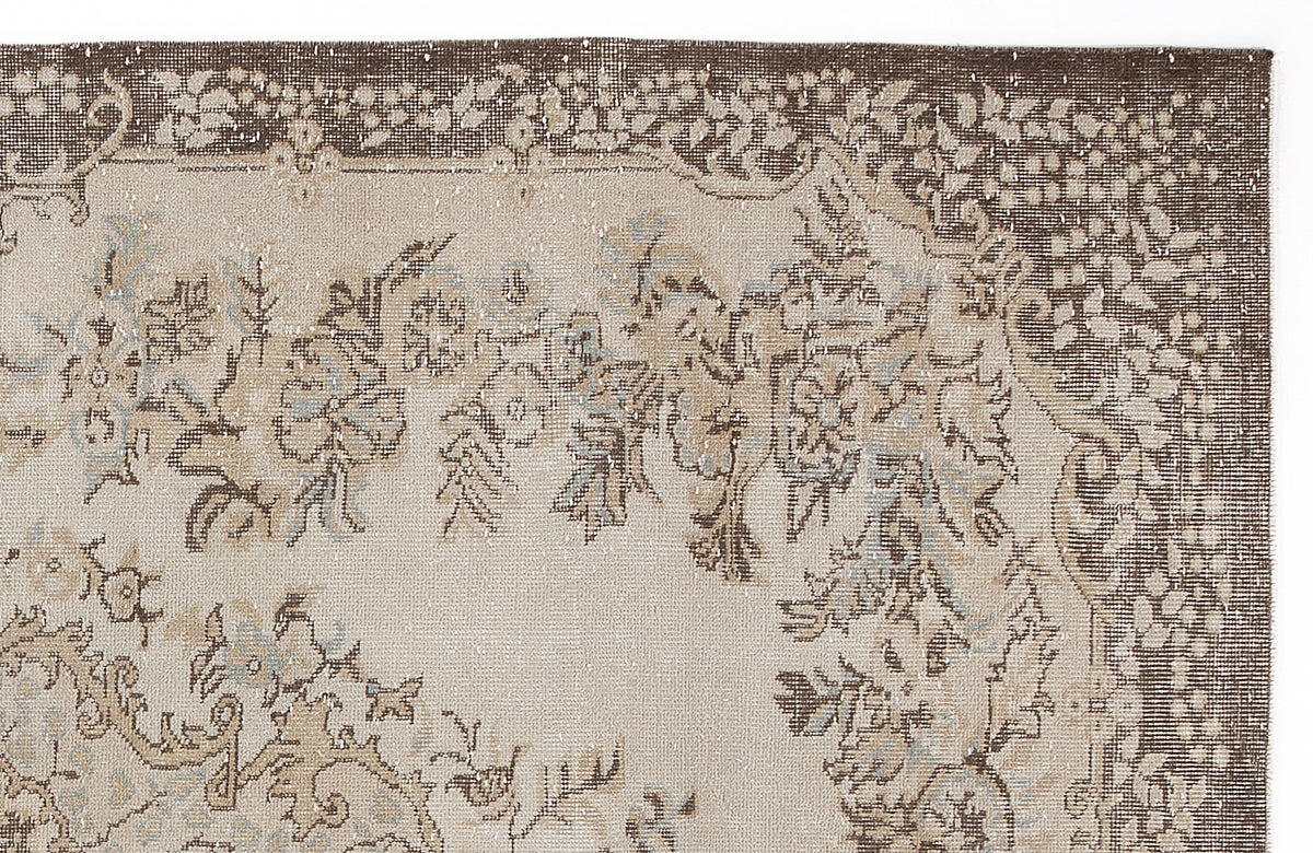 Beige and brown vintage-style rug with a floral medallion pattern and distressed texture on a white background.