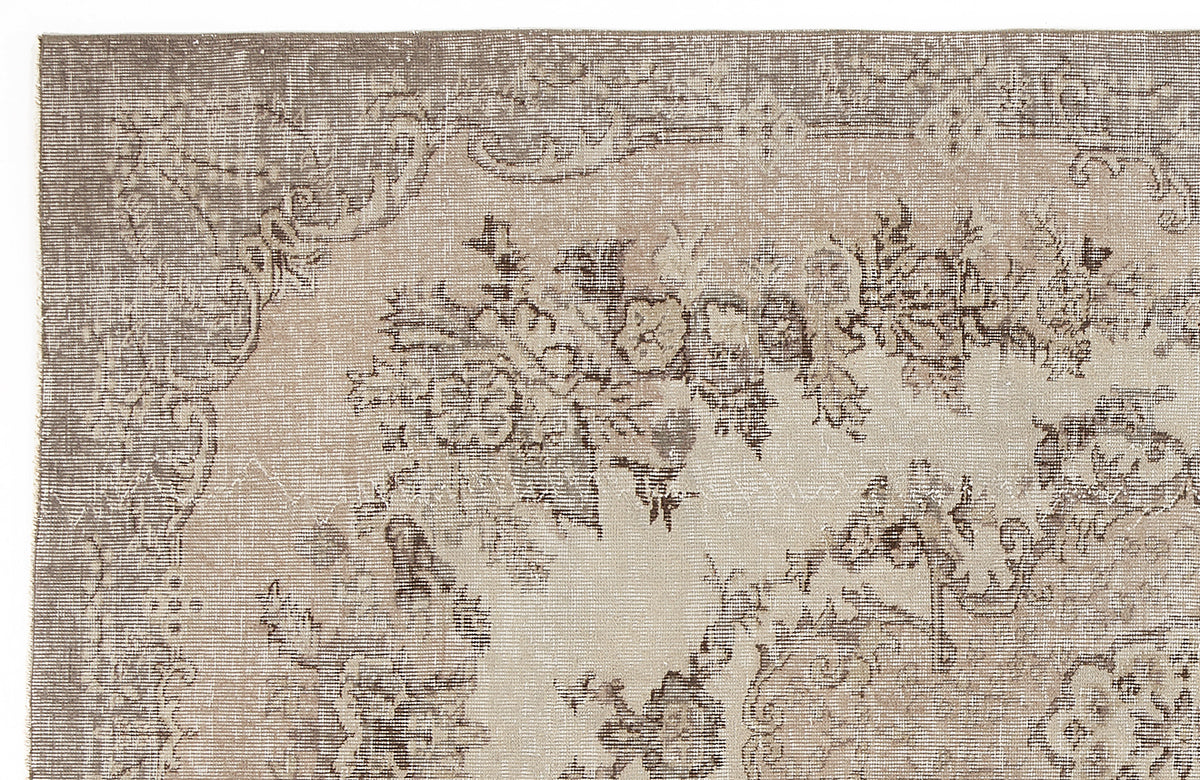 Taupe and beige vintage-style rug with a distressed floral medallion pattern.