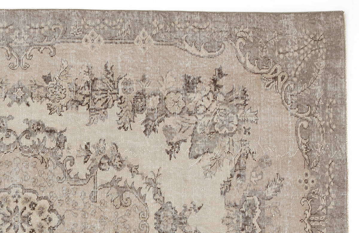 Taupe and beige distressed rug with a faded traditional floral medallion pattern.