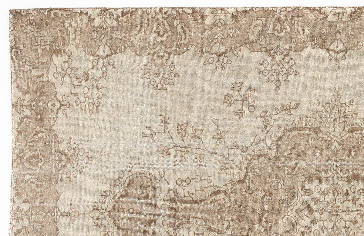Beige and taupe rug with a distressed traditional floral medallion pattern on a white background.