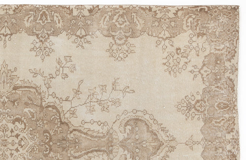 Load image 1 in gallery view. Beige and taupe vintage-style rug with a faded floral medallion pattern on a white background.