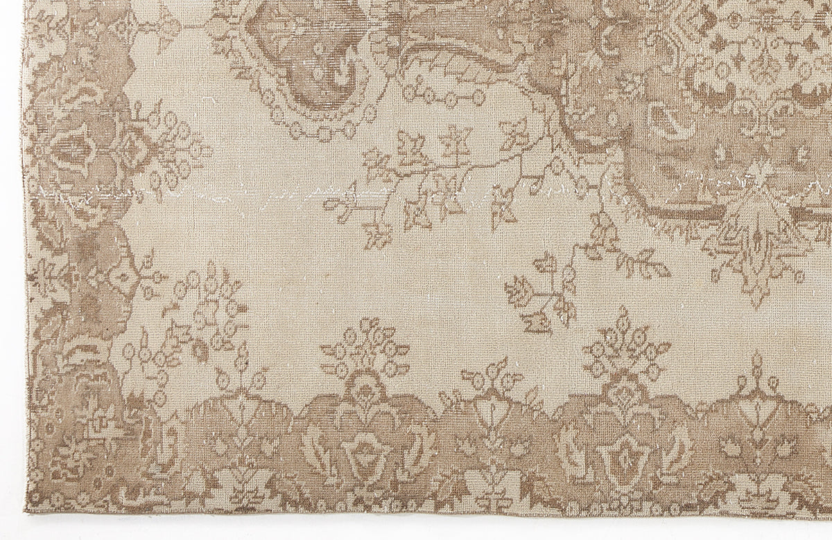 Beige and taupe distressed rug with a traditional floral medallion pattern and ornate border.