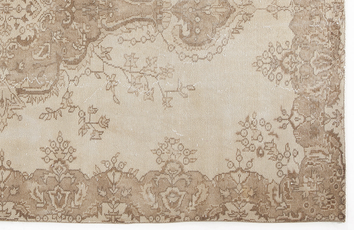 Beige and taupe vintage-style rug with a distressed floral medallion pattern and ornate border.