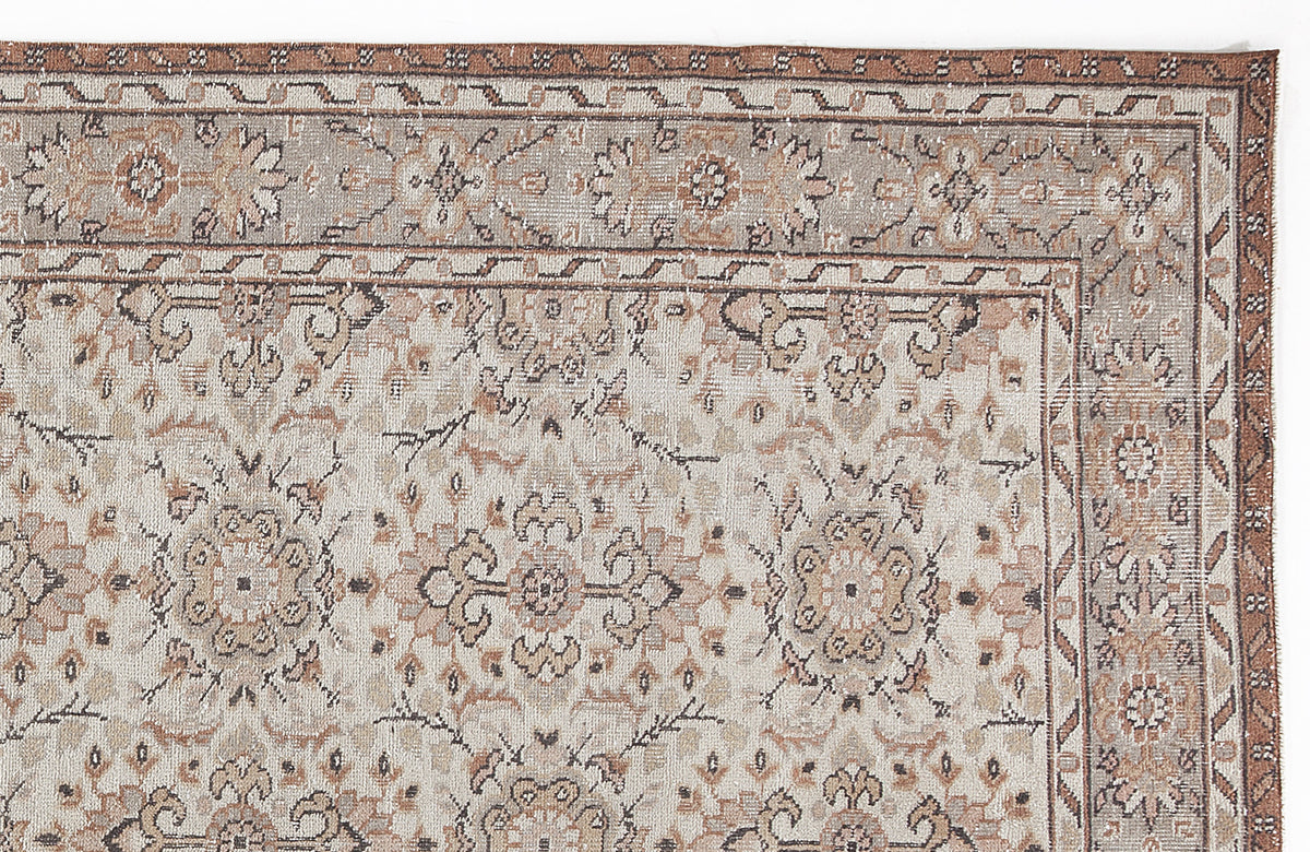 Beige and brown traditional rug with a distressed floral medallion pattern and a geometric border.
