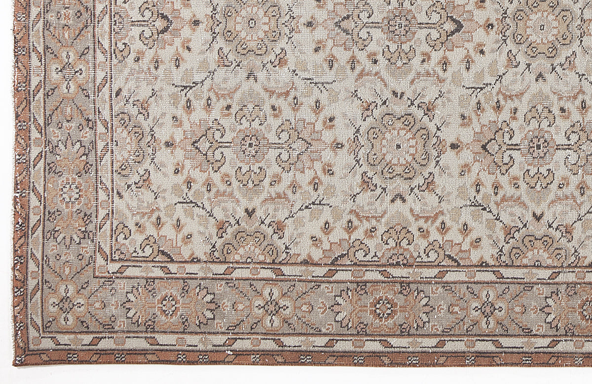 Beige and brown traditional rug with a distressed floral medallion pattern and a geometric border.