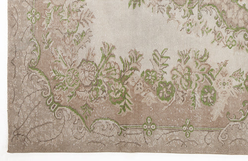 Load image 1 in gallery view. Beige and taupe distressed rug with a green floral border and medallion pattern.