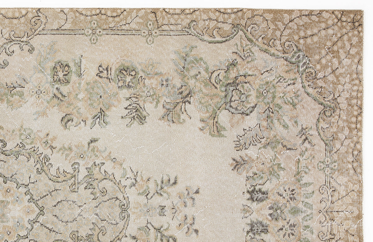 Beige and sage green traditional rug with a distressed floral medallion pattern on a white background.