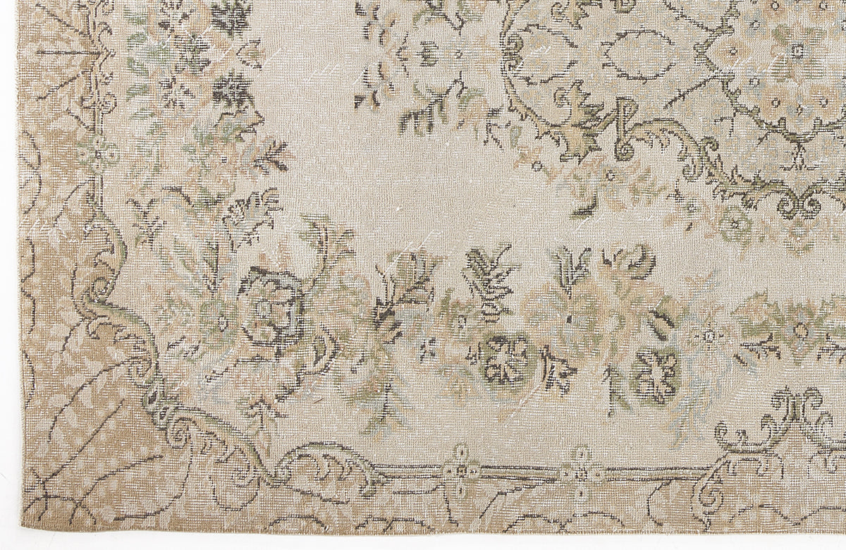 Beige and cream vintage-style rug with a distressed floral medallion pattern and muted green and brown accents.