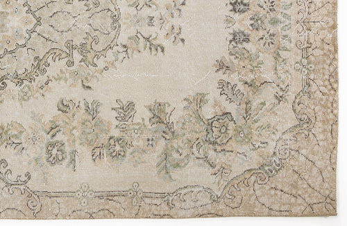 Load image 1 in gallery view. Beige and tan distressed rug with a faded floral medallion pattern and muted green accents.