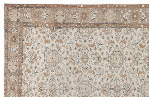 Load image 1 in gallery view. Tan, cream, and grey traditional rug with a distressed floral medallion pattern and a wide decorative border.