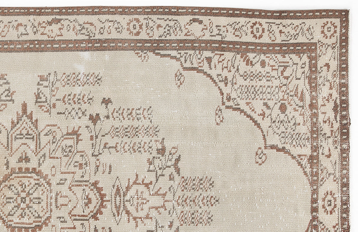 Beige and brown traditional rug with a distressed medallion pattern and ornate border.